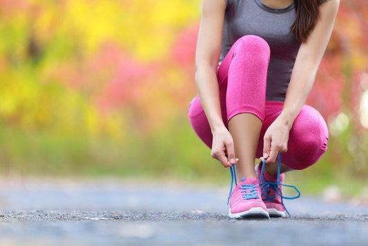 girl tying up laces on running shoes