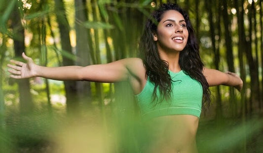 girl in a forest wearing a green top